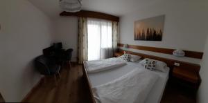 考那亚诺Landhaus Weingut的卧室配有白色的床和窗户。