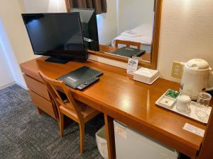 苅田町Blue Port Hotel Kitakyushu Airport的一张桌子,上面有一台电脑和一台电视机