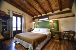 Orísoainpalacio de Orisoain的一间卧室设有一张大床和绿色的墙壁