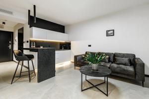 卢布林PLATiNIUM HOUSE&SPA BASEN-SAUNA CENTRUM的客厅配有沙发和桌子