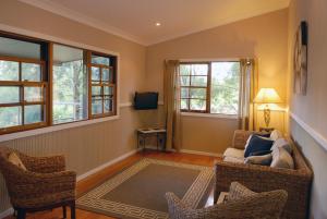 格洛斯特Barrington Hideaway- River Cottages的客厅配有椅子、沙发和窗户