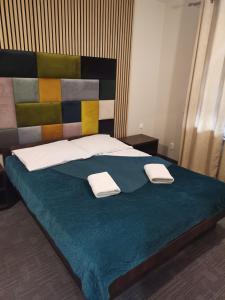 罗兹Uslugi hotelowe A1的一间卧室配有一张床,上面有两条毛巾