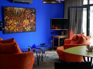 欧布纳Suite 24的蓝色的客厅配有橙色椅子和电视
