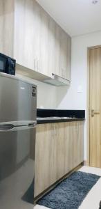 马尼拉S Residences-MOA的厨房配有木制橱柜和炉灶。