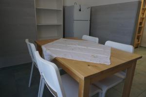埃尔丁Bett3de的一张带白色椅子的木桌和白色冰箱