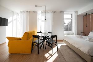 梅拉诺Guesthouse diWINE的一间卧室配有桌子、黄椅和床