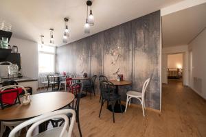 梅拉诺Guesthouse diWINE的一间带桌椅的用餐室和一面墙
