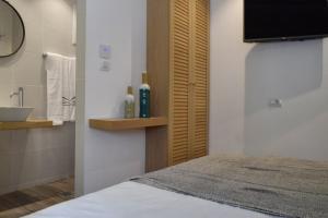 斯基亚索斯镇Meltemi by Manthos Hotels的一间带水槽的浴室和一张位于客房内的床