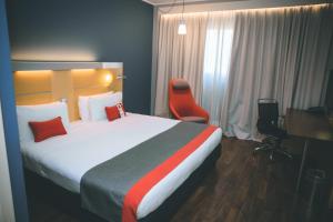 卡萨诺韦米兰马尔彭萨快捷假日酒店的酒店客房设有一张大床和一张书桌。