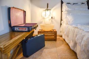 法萨诺Cortebbianca的一间卧室配有一张床、一个手提箱和一张桌子