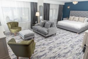 GeesalaErris Coast Hotel的酒店客房配有一张床、一张沙发和椅子。