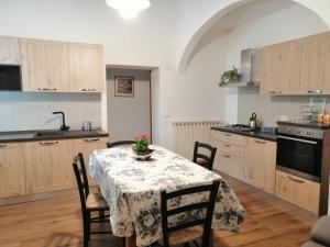 托里塔迪谢纳La Dimora degli Olivi的厨房配有一张桌子,上面放着花瓶