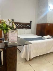 阿雷基帕Hotel La Posada Del Sol的一间设有两张床和一张花卉玻璃桌的房间