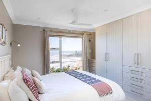 拉姆斯盖特Ramsgate Palms Accommodation的一间卧室设有一张床和一个大窗户