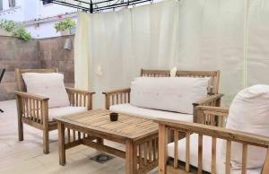 塞维利亚Apartamento Los Naranjos de Santa Justa的庭院配有两把椅子和一张带枕头的桌子。