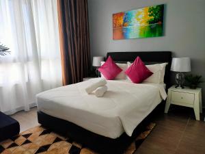 哥打巴鲁Izz'man Homestay Level 33 Troika Kota Bharu的卧室配有带粉红色枕头的大型白色床
