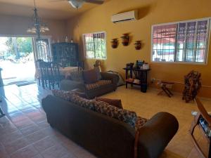 Las UvasBEAUTIFUL HOUSE IN LAS UVAS SAN CARLOS, PANAMA WITH FRUIT TREES -SWIMMING POOL的客厅配有沙发和椅子