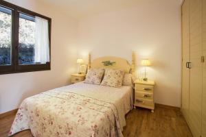 克拉尔夫斯Ca la Manet的一间卧室配有带2个床头柜和1扇窗户的床