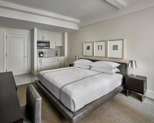 纽约AKA中央花园酒店的一间白色卧室,配有一张大床和一个厨房
