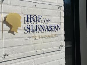 斯莱纳肯Hof van Slenaken - Hotel & Apartments的白色砖墙边的标志