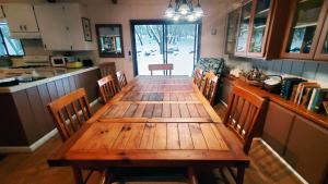 朱利安Pine Hills Cabin in Julian的厨房配有一张木桌和椅子,厨房配有一张桌子和一张柜台