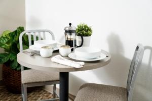 杰克逊InTown Suites Extended Stay Jackson MS的一张桌子,上面有盘子和杯子,上面有咖啡壶