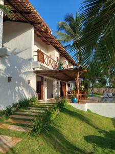 普雷亚Villa Aracoara的院子里有棕榈树的白色房子