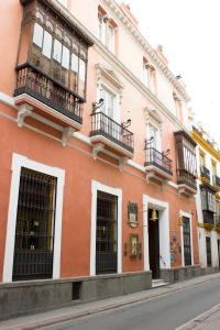 塞维利亚阿拉巴德罗酒店的一座位于城市街道上的橙色建筑,设有阳台