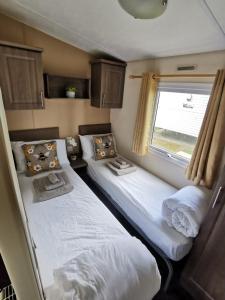 纽基Newquay Caravan Holiday的小型客房 - 带2张床和窗户