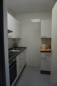 埃尔丁Bett3de的小厨房配有白色橱柜和水槽