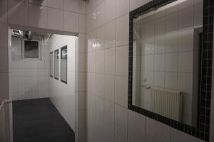 埃尔丁Bett3de的浴室设有白色瓷砖墙壁和镜子
