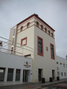 RocianaHostal Monteluna的白色的建筑,边有红色的窗户