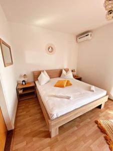 普纳特The Manzoni family 5的一间卧室配有一张铺有木地板的白色床单。