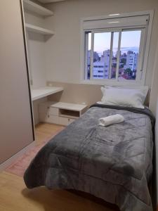 本图贡萨尔维斯Apartamento bem localizado的一间卧室设有一张大床和窗户