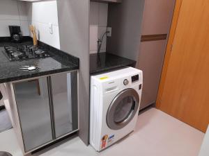 本图贡萨尔维斯Apartamento bem localizado的厨房配有洗衣机和炉灶。