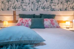 德尔锡伦西奥海岸Ke Casetta Tenerife的一间卧室配有一张带蓝色枕头的床和壁纸