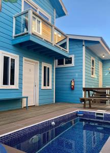 乌蒂拉Moon Apartments的蓝色的房子,设有游泳池和甲板