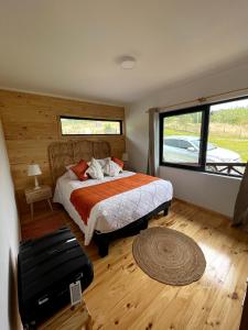 巴拉斯港Moon River Puerto Varas的一间卧室设有一张床和一个大窗户
