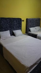 弗里敦Jennabwa Lodge and Restaurant的黄色墙壁的客房内的两张床
