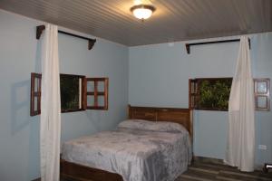 AntónCabaña Kundalini的一间卧室设有一张床和两个窗户。