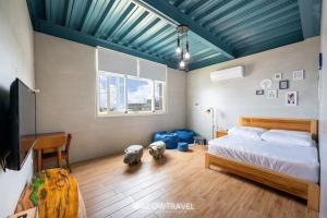 小琉球岛小琉球流浪背包客栈的一间卧室设有一张床和蓝色的天花板