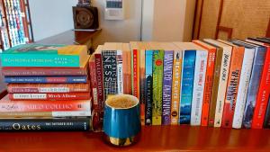 美岸Hotel Mercante的桌上的一堆书,加上一杯咖啡