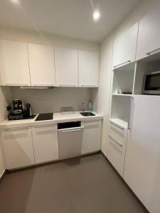 VaraksinoАпартаменты частные в Резиденс Завидово的厨房配有白色橱柜和白色冰箱。