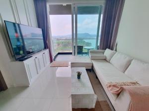 邦萨雷Delmare Beachfront Bangsaray Premium Condominium的客厅配有白色沙发和平面电视。