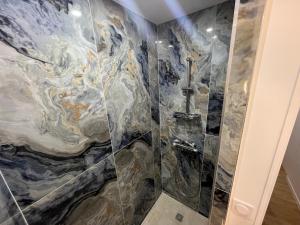 Saint EtienneAppartement Luxe Jaune的一间带大理石效果淋浴间的浴室