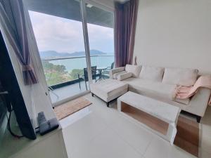 邦萨雷Delmare Beachfront Bangsaray Premium Condominium的带沙发和大窗户的客厅