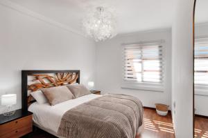 科拉雷侯Villa Corralejo的白色卧室配有一张床和一个吊灯