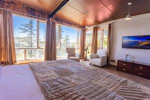 西姆拉Seclude Shimla, Taraview的一间卧室设有一张大床和大窗户