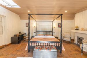 西姆拉Seclude Shimla, Taraview的一间卧室设有一张天蓬床和一个壁炉