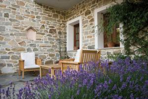 Emporio卡司达诺达索斯别墅的石头房子,带两把椅子和紫色花